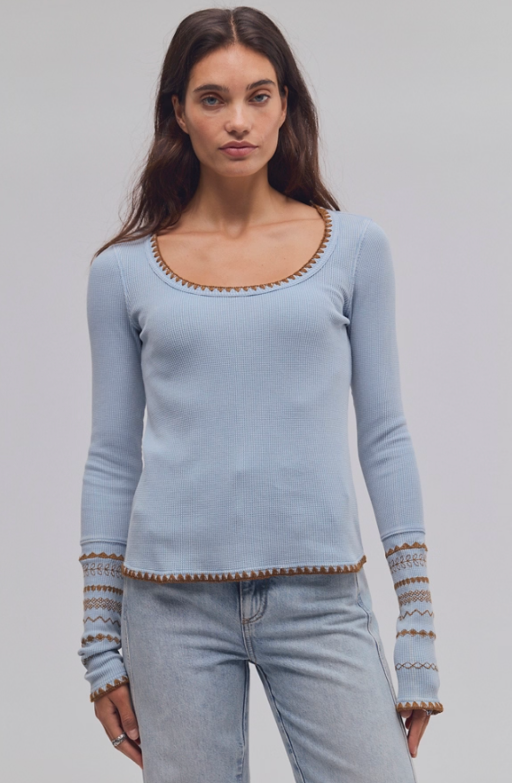 Model wearing Trestles Clothing Company light blue waffle knit thermal top with brown contrast stitching and cuffs