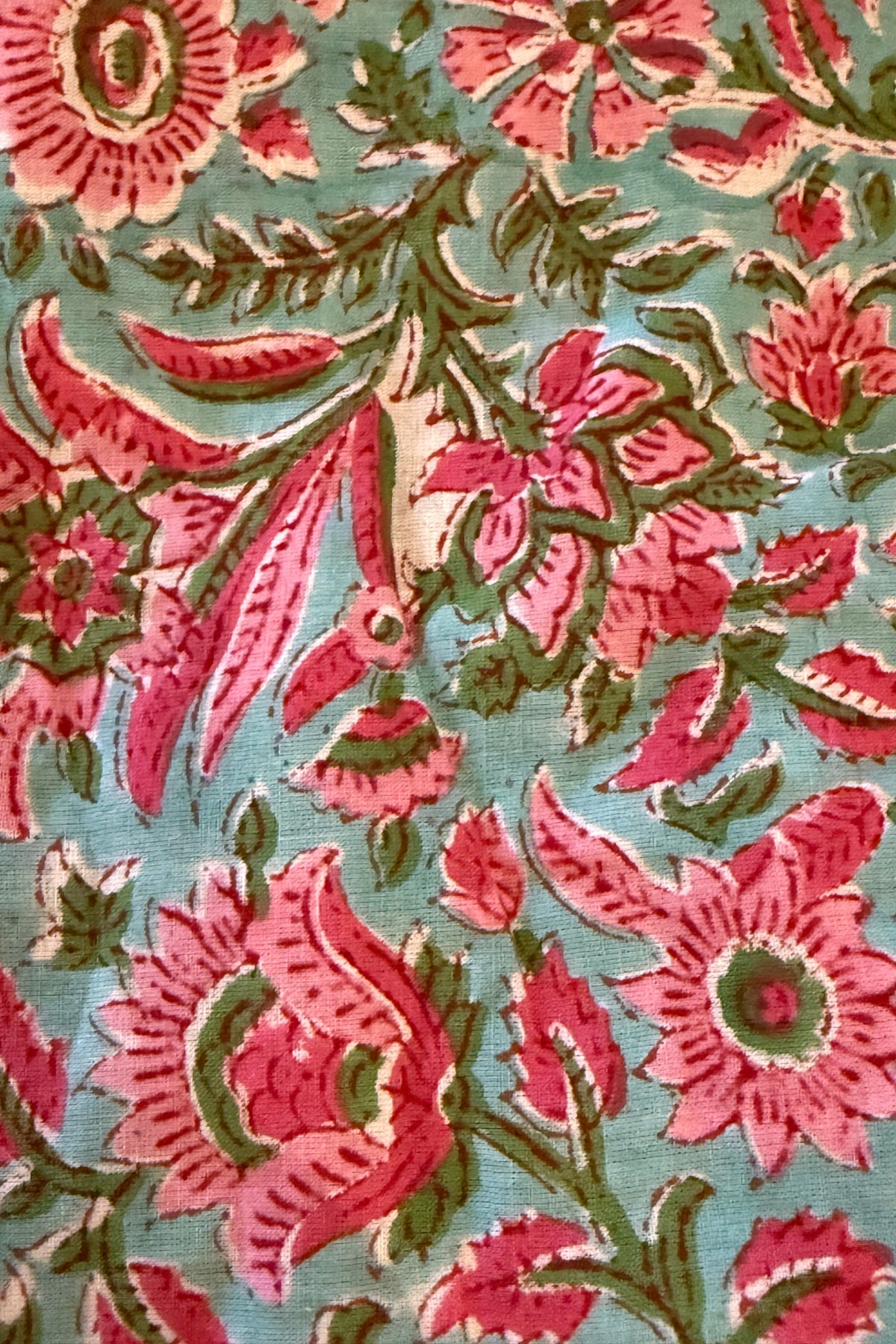Trestles Clothing Company cotton fabric featuring a vibrant floral boho print in pink, green, and turquoise blue.