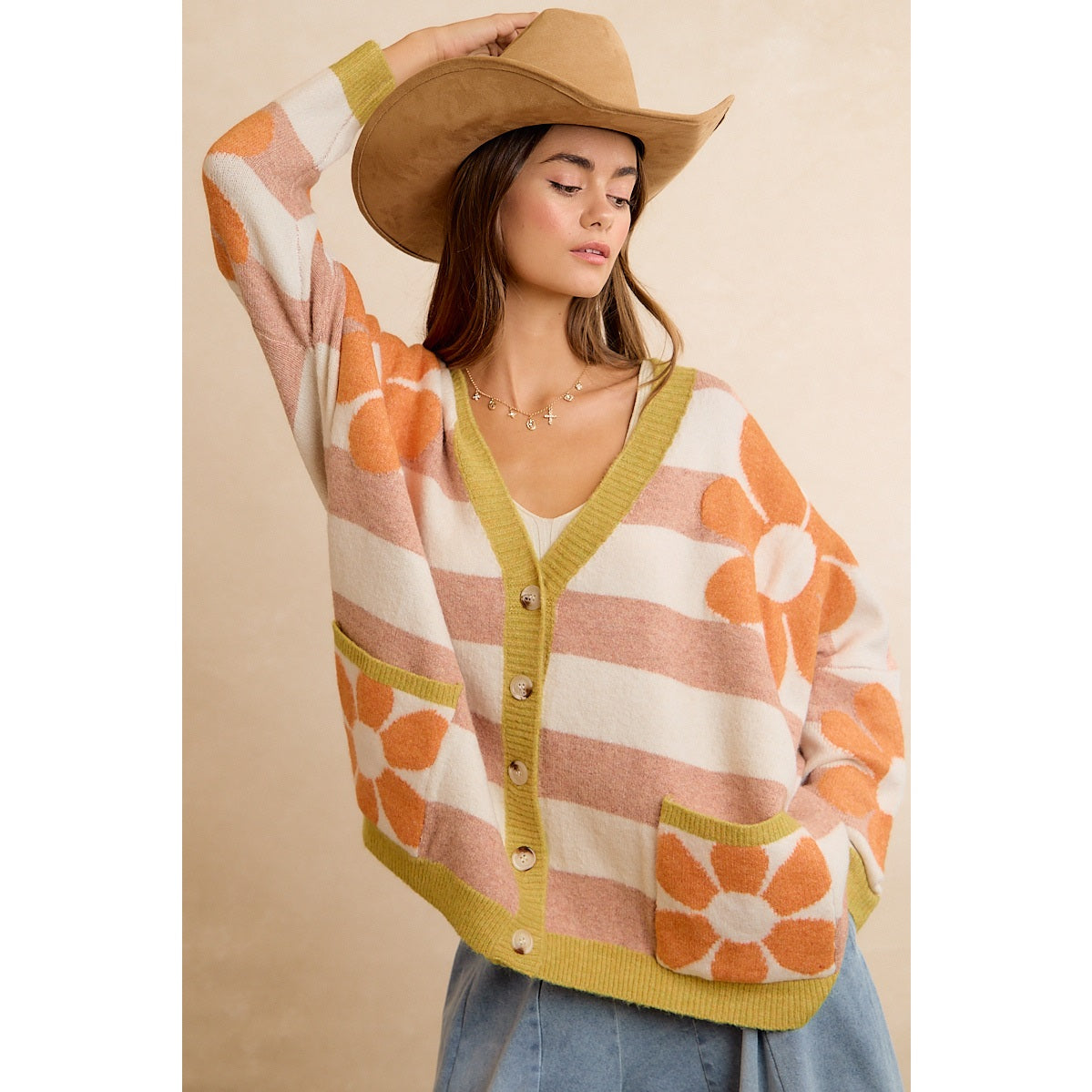 Trestles Clothing Company oversized knit cardigan with orange flowers and stripes, worn by a model in a cowboy hat.
