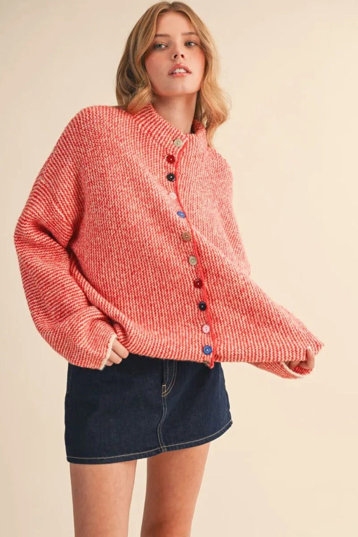 Model wearing a Trestles Clothing Company cozy red knit sweater with unique mismatched buttons and a mock neck.