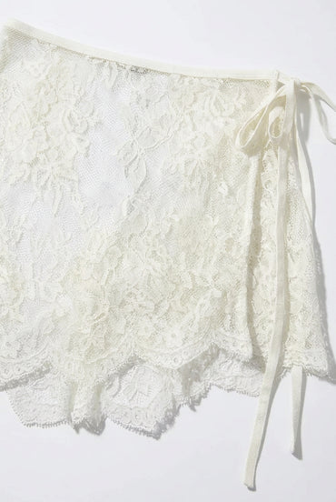 Trestles Clothing Company white asymmetrical lace skirt overlay with a tie-side closure and scalloped hem.