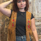 Person wearing a brown fringe vest with floral embroidery against a rustic wooden background