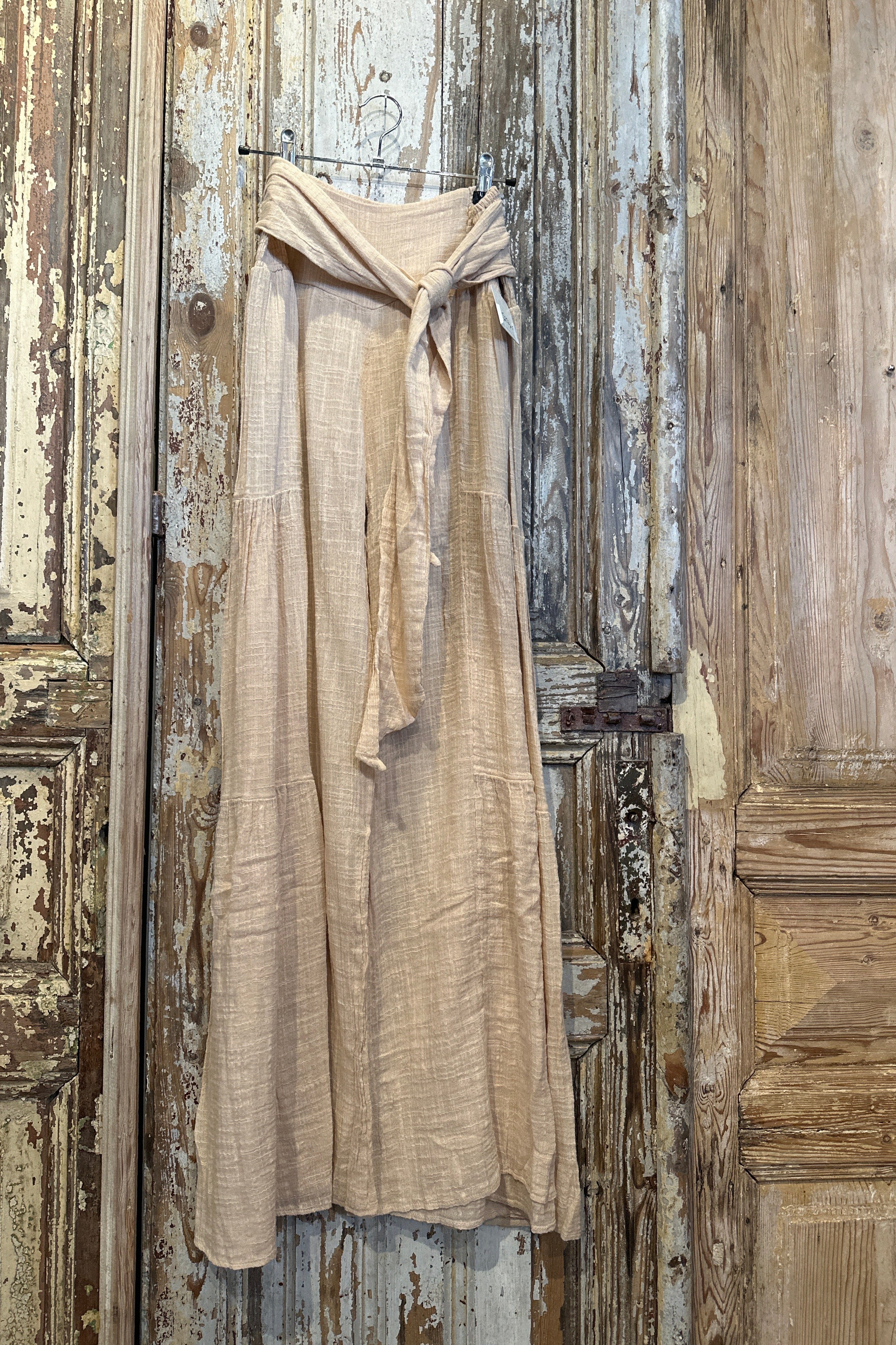 Beige dress hanging on a rustic wooden door