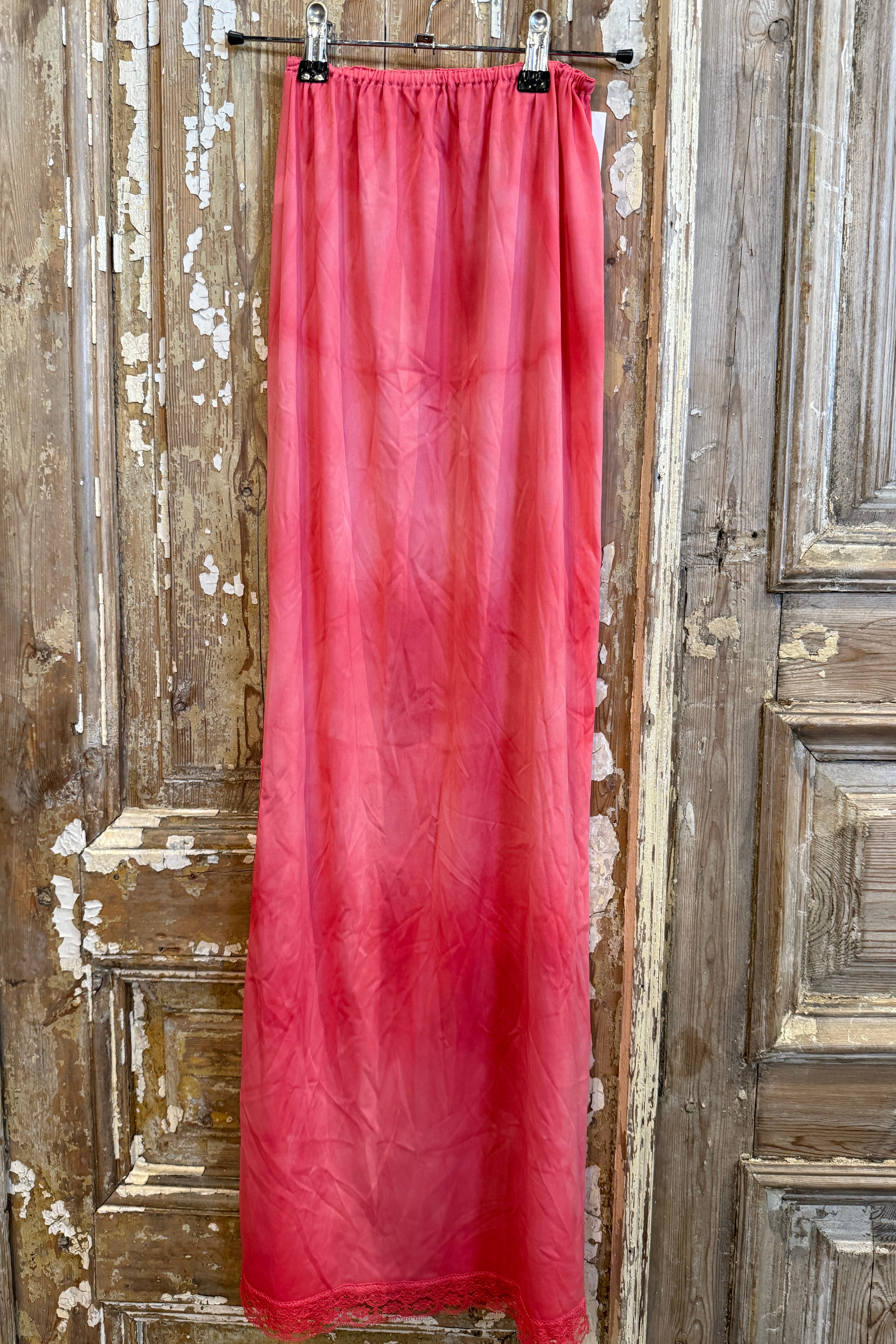 Red fabric on a wooden surface with peeling paint