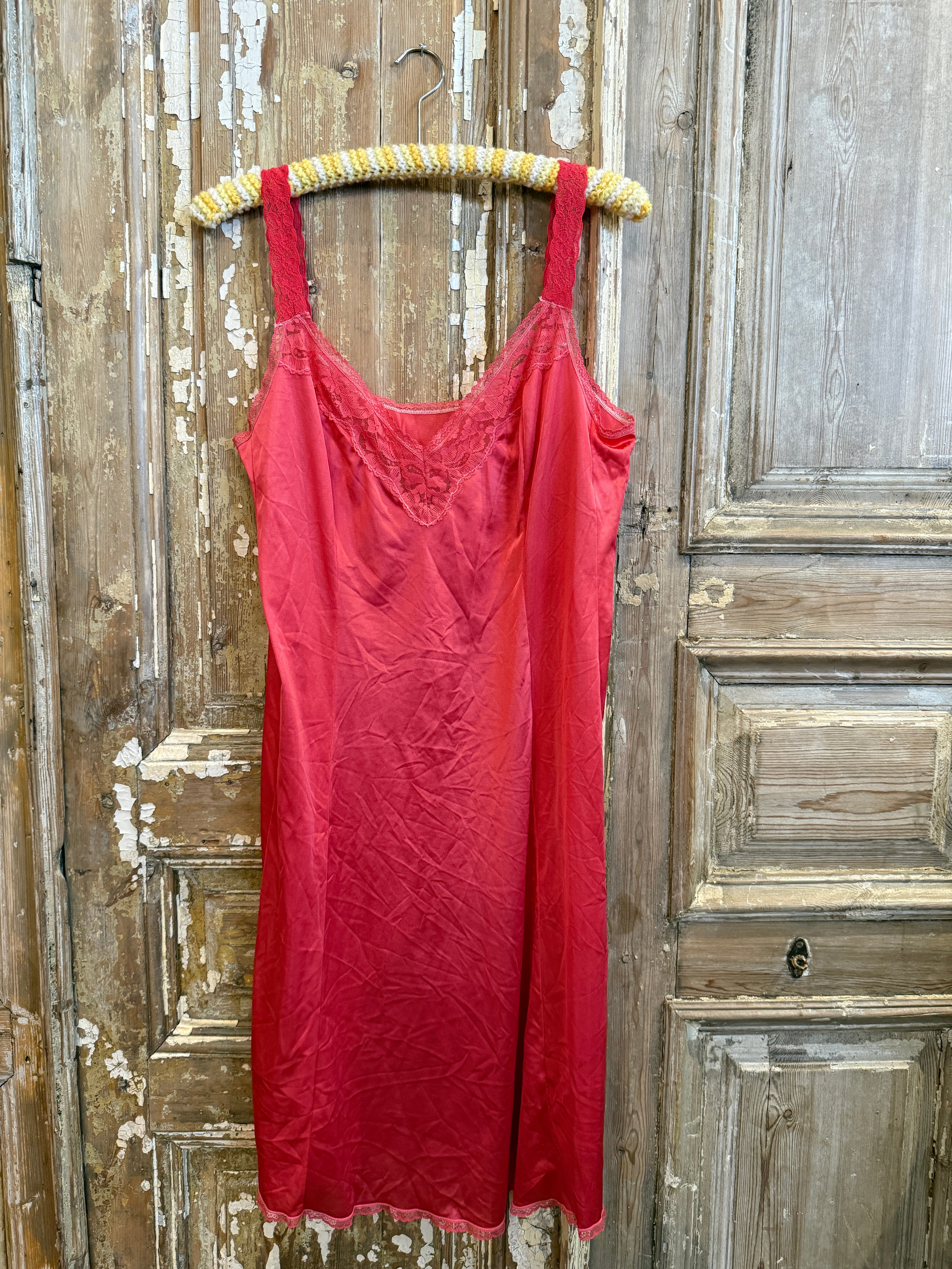 Red dress on a wooden surface with a decorative belt