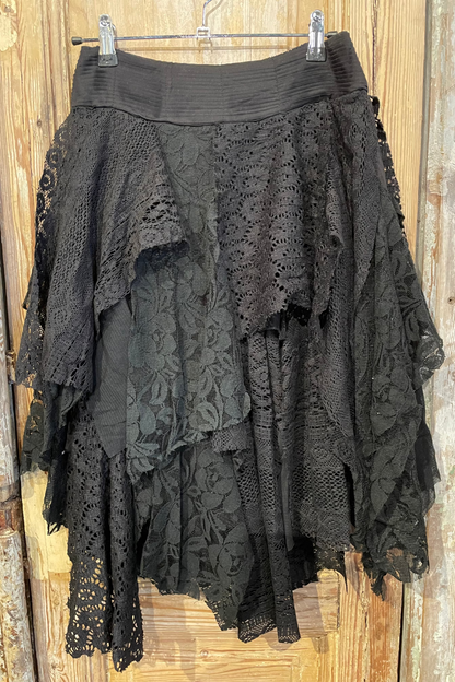 Black lace skirt hanging on a wooden surface