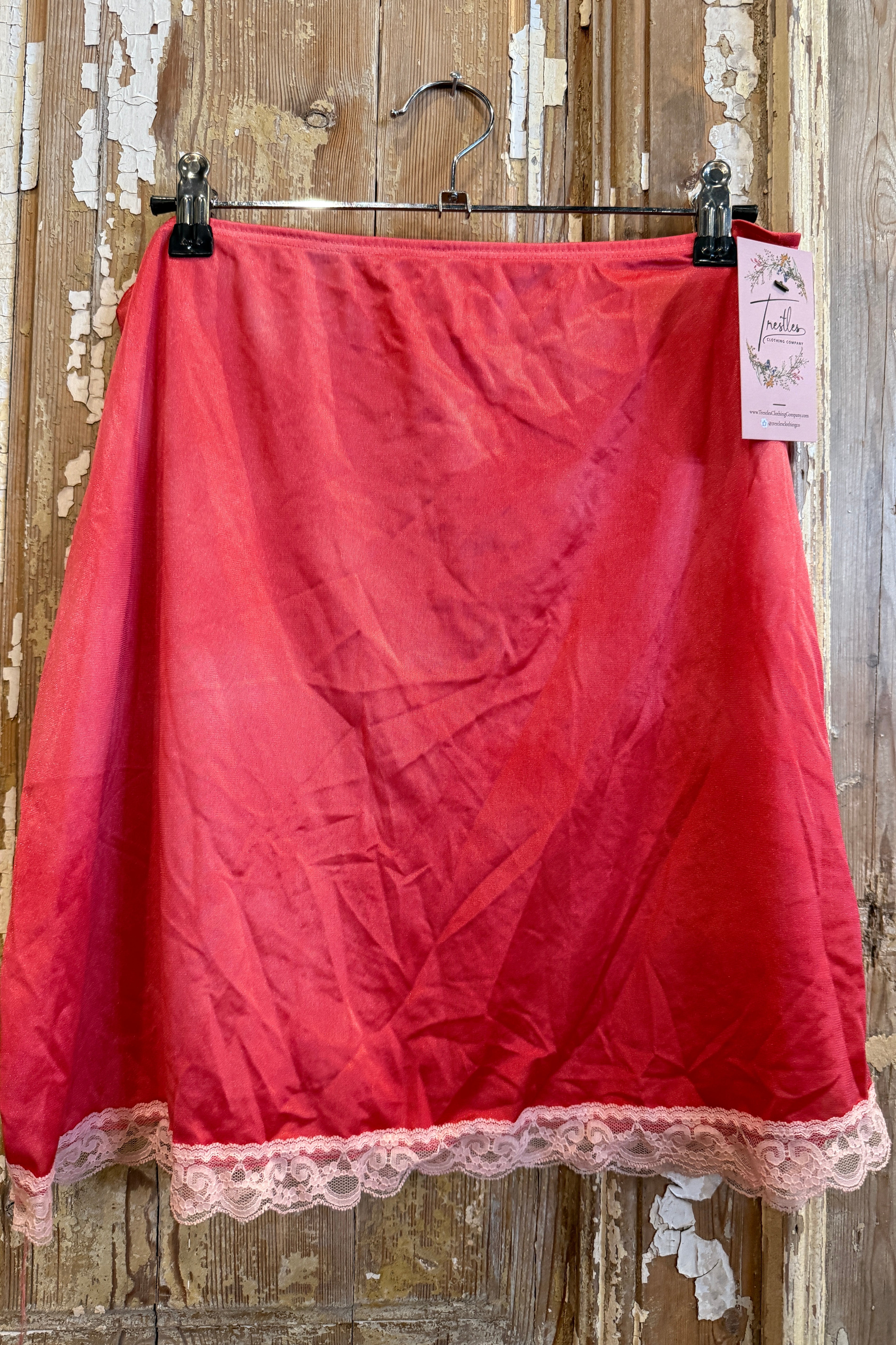 Red fabric with lace trim on a wooden surface