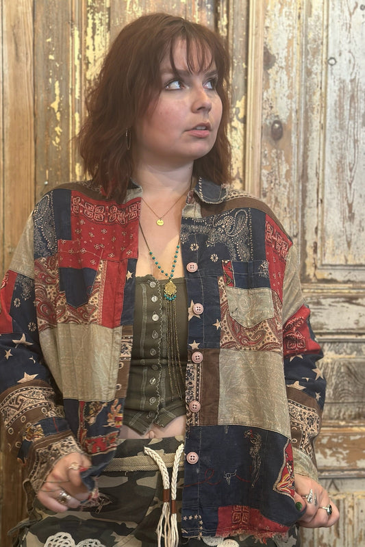Woman wearing a patchwork jacket in a rustic setting