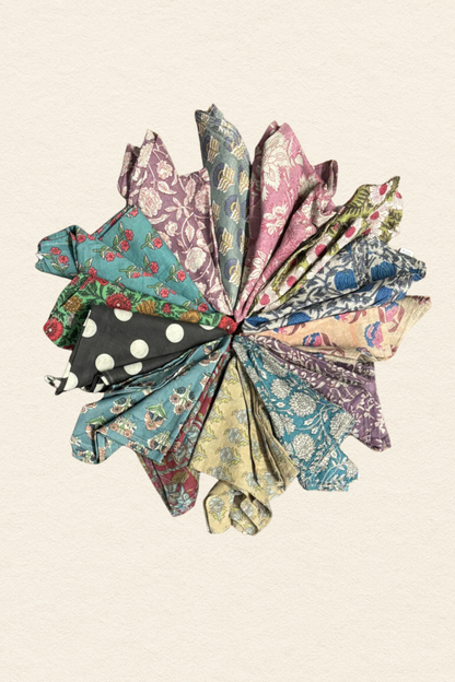 Colorful fabric flowers arranged in a circular pattern on a beige background