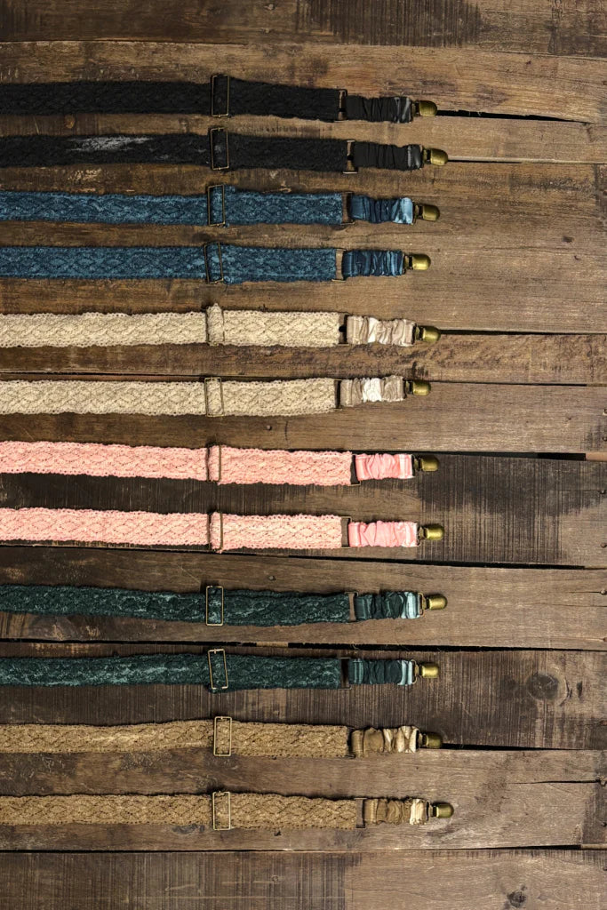 Set of leather straps with metal clasps on a wooden surface