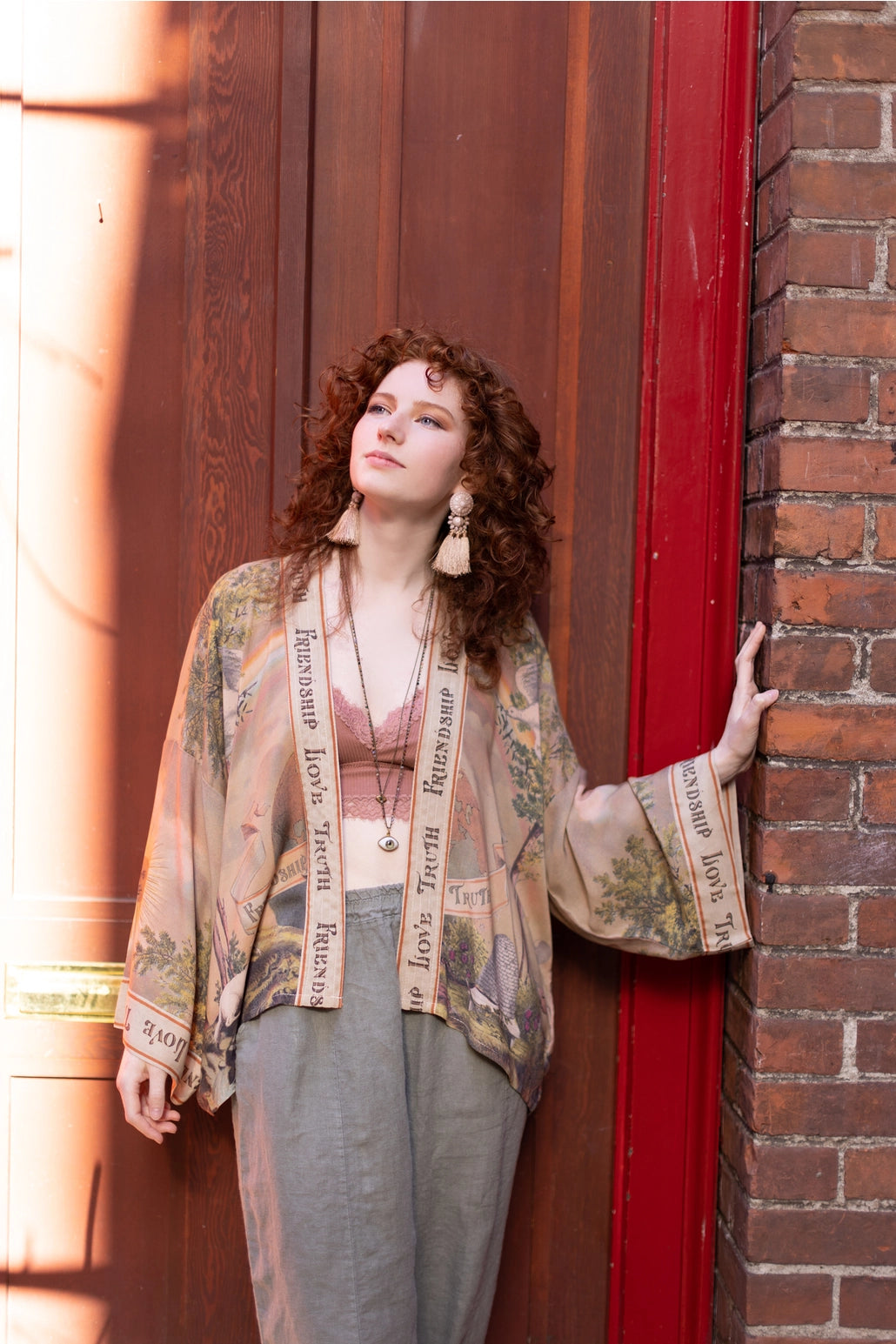 Trestles Clothing Company bamboo cropped kimono with vintage print worn by a woman against a brick wall