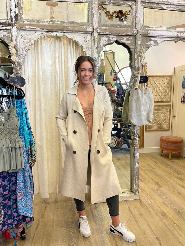 Trestles Clothing Company Beckham Coat in beige cashmere blend, a midi-length sweater coat worn by a smiling woman.