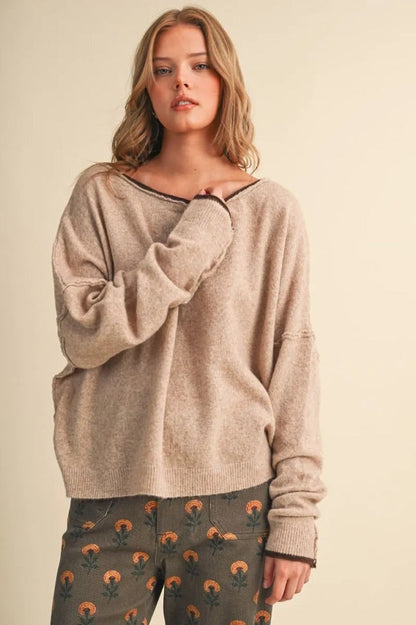 Trestles Clothing Company relaxed beige boatneck sweater with contrast dark trim and drop shoulder sleeves on a model.