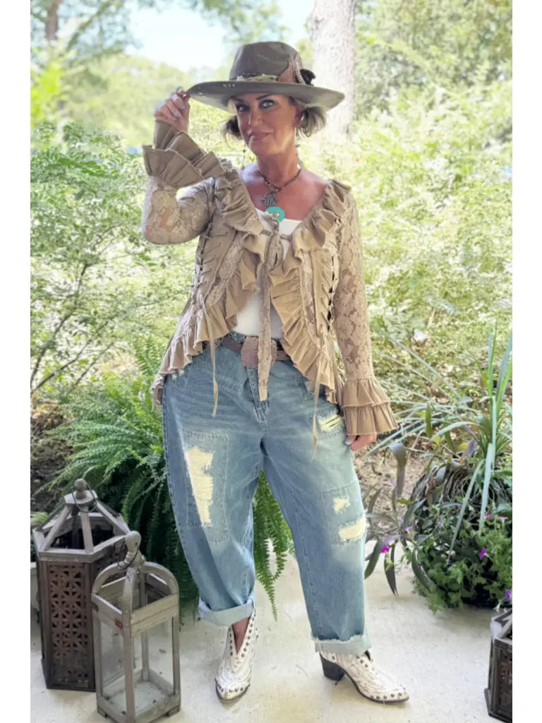 Trestles Clothing Company beige lace ruffled jacket with front ties worn by a woman in a hat and distressed jeans