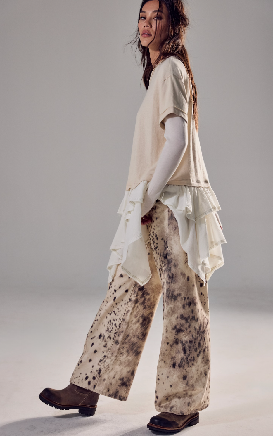 Model wearing Trestles Clothing Company Tattered Love Tee, a beige knit top with double-layer peplum and short sleeves.