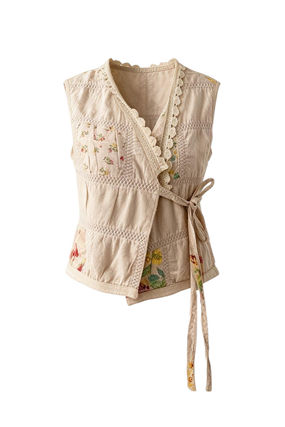 Trestles Clothing Company beige wrap vest with floral patches, lace trim, and side tie closure.