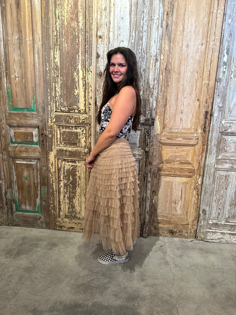 Trestles Clothing Company beige ruffled tulle maxi skirt with an elastic waistband worn by a woman