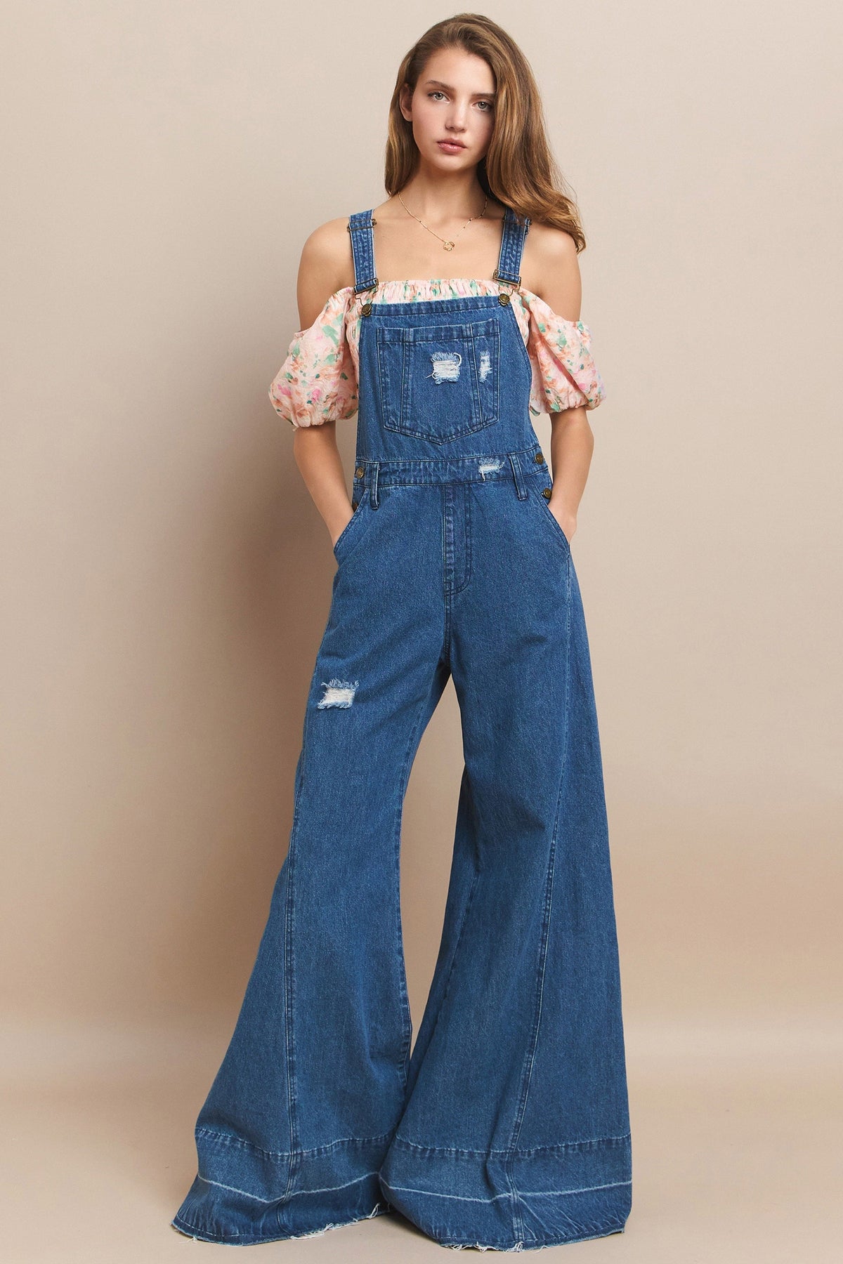 Trestles Clothing Company extreme bell bottom denim overalls with distressed details and wide flared legs on a model
