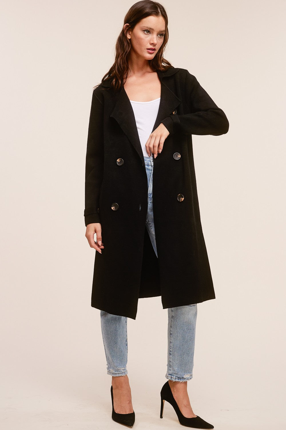 Model wearing a black Trestles Clothing Company Beckham midi sweater coat in a cashmere blend over jeans and heels