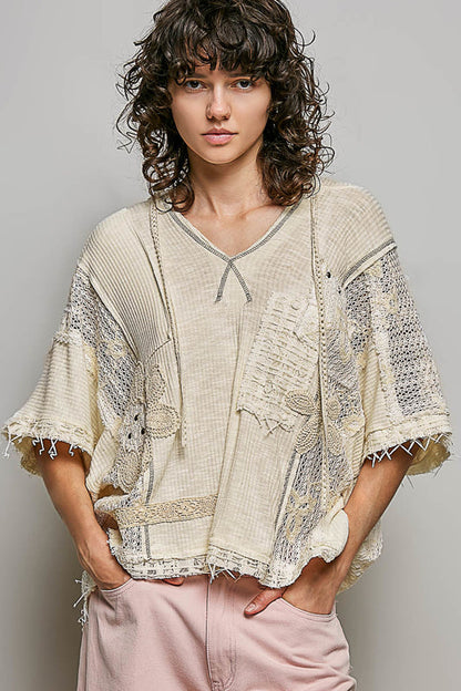 Trestles Clothing Company beige boho patchwork V neck hoodie with lace panels, crochet floral details, and raw edges.