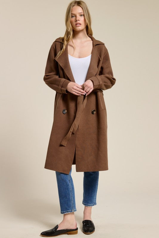 Model wearing a brown Trestles Clothing Company Beckham midi sweater coat with an optional tie belt over jeans