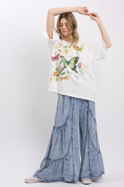 Trestles Clothing Company butterfly graphic tee with ruffled sleeves paired with wide-leg mineral washed denim pants