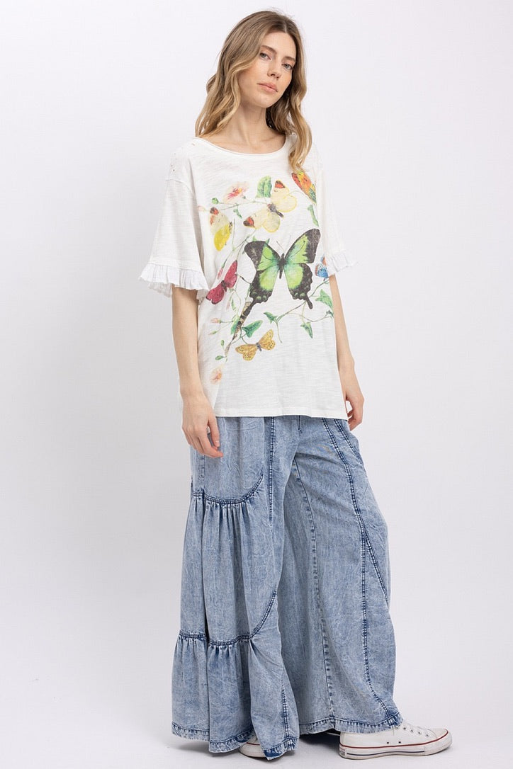 Trestles Clothing Company butterfly graphic tee with ruffled sleeves, mineral washed cotton, and wide-leg denim pants.