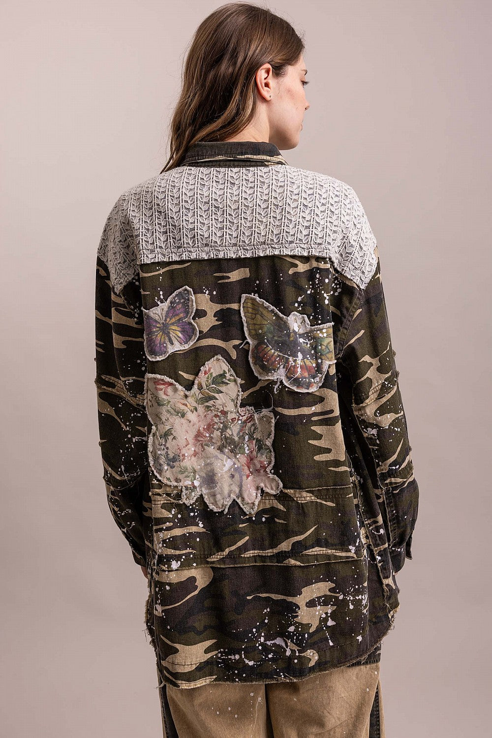 Trestles Clothing Company camo shacket with floral and butterfly patches, paint splatters, and a knit back panel.