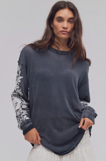 Model wearing a charcoal grey Free People Flora long sleeve cotton tee with floral sleeve details by Trestles Clothing Company