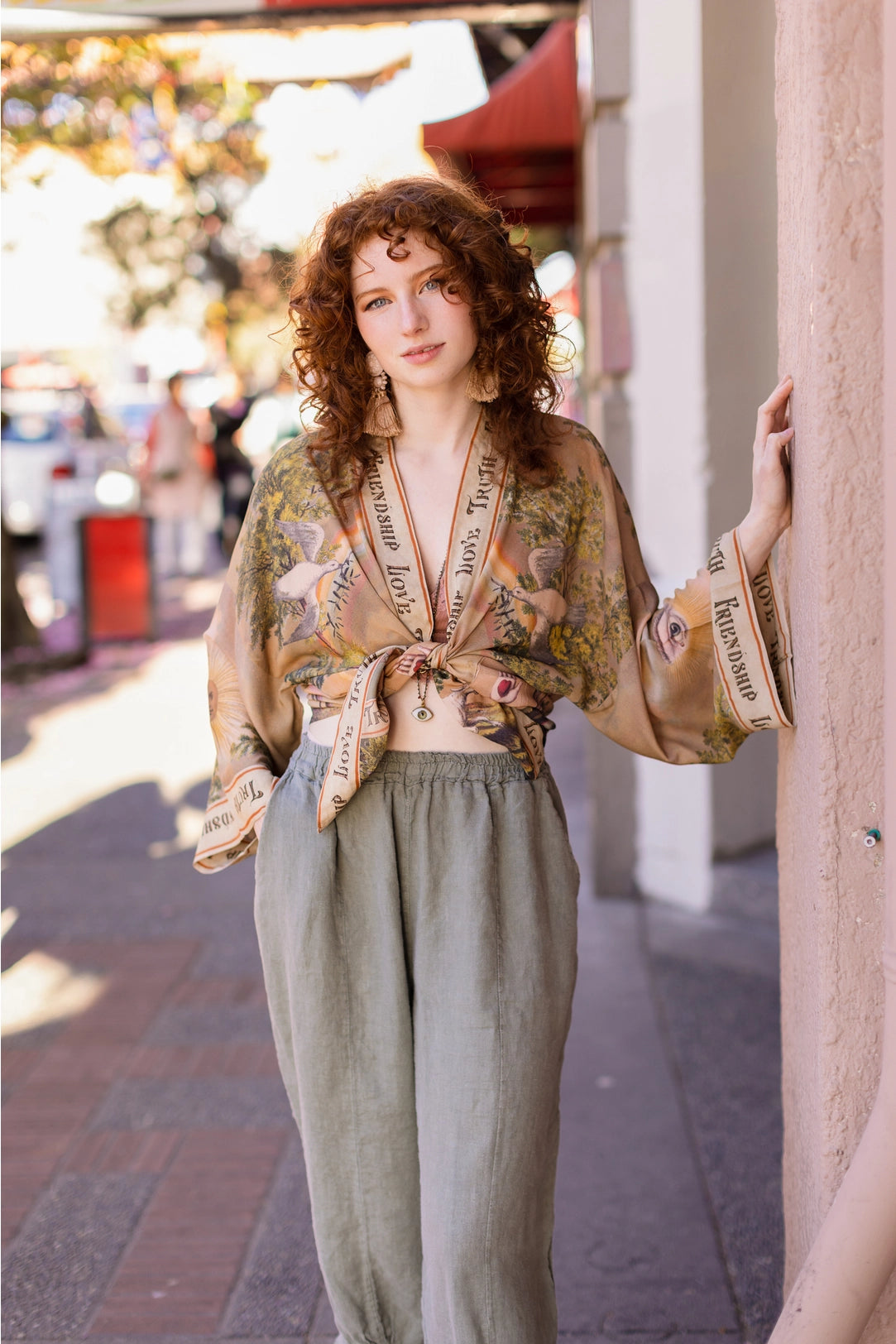 Trestles Clothing Company cropped bamboo kimono with vintage print worn by a woman with curly red hair on a street.