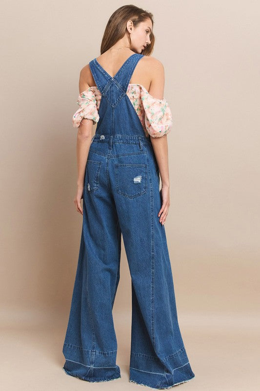 Trestles Clothing Company extreme bell bottom denim overalls with wide legs and distressed back pockets on a model