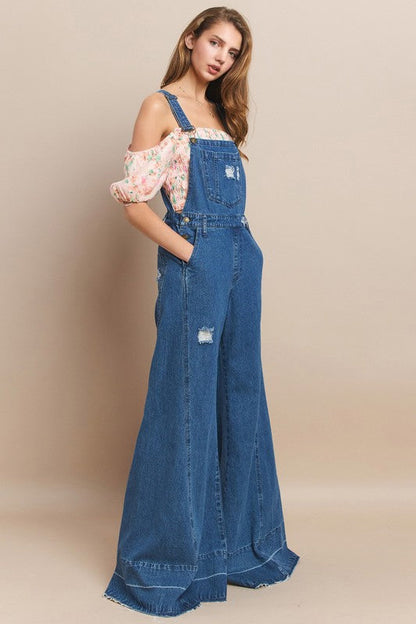 Trestles Clothing Company denim overalls with extreme bell bottoms and distressed details worn by a model