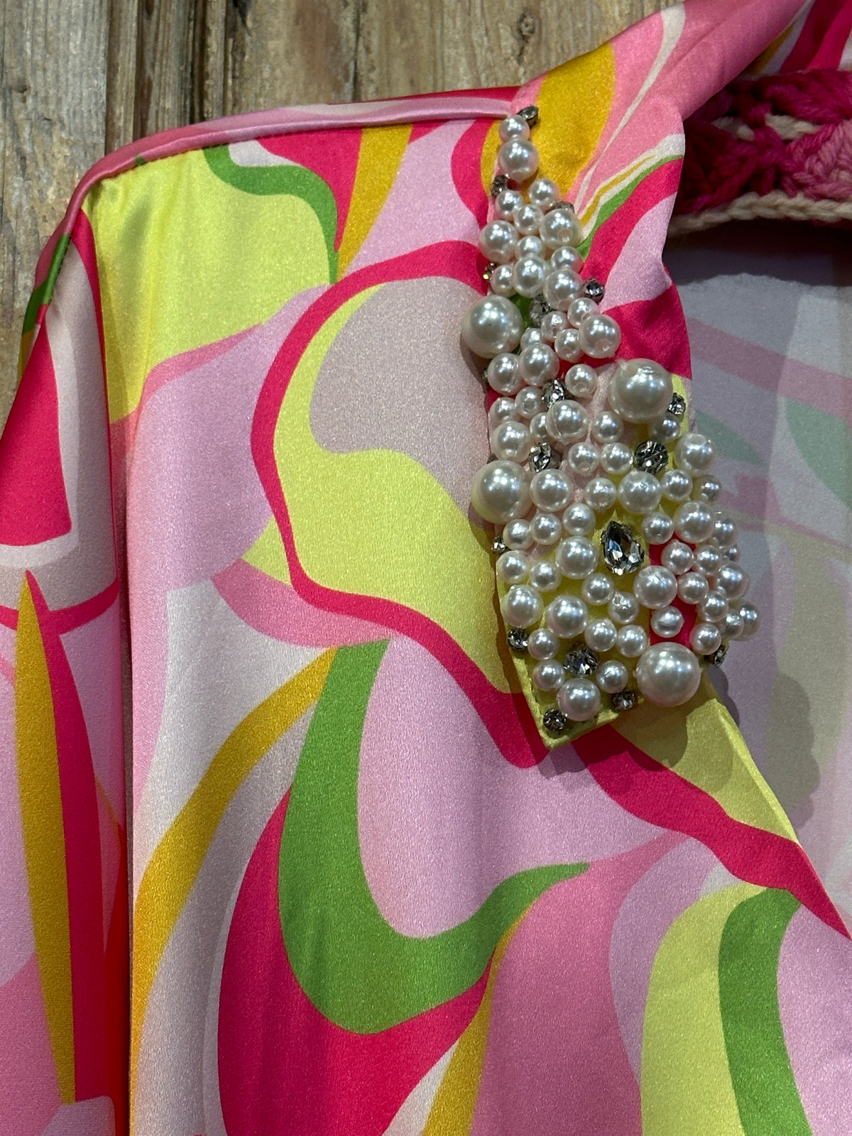 Trestles Clothing Company disco bodysuit featuring a vibrant pink, yellow, and green swirl print with pearl collar