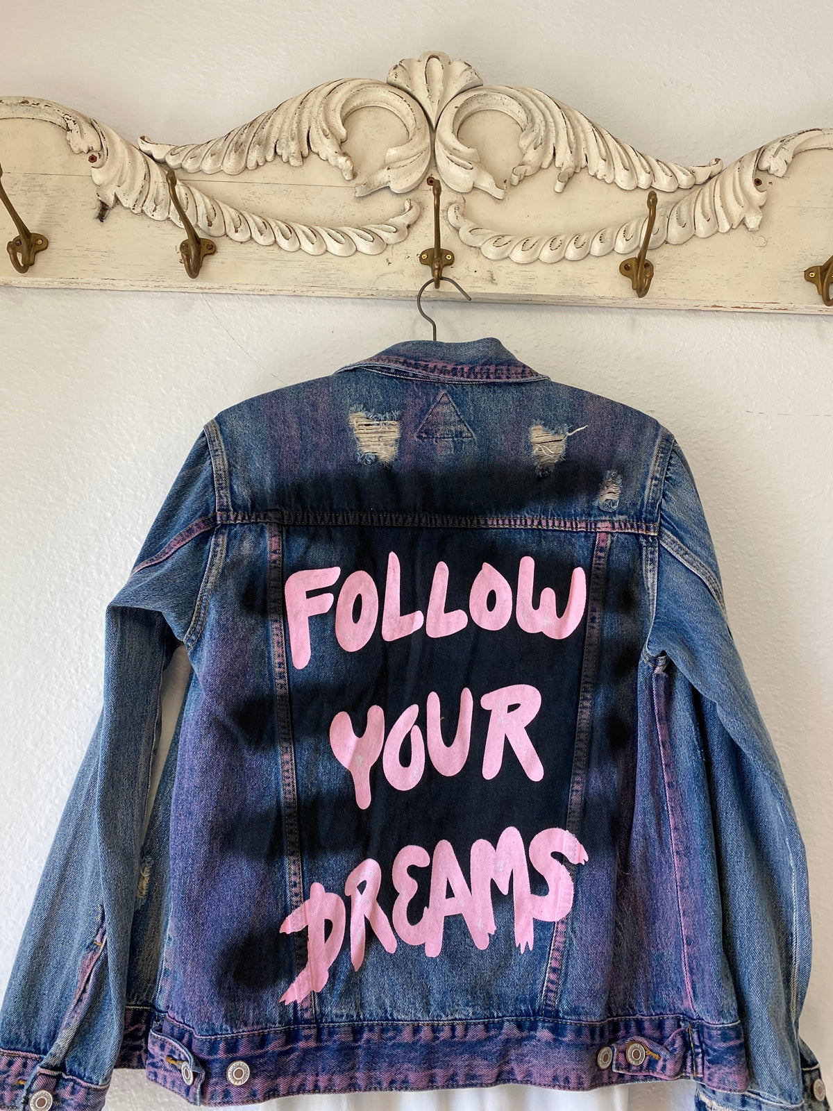 Trestles Clothing Company distressed denim jacket with hand-painted pink Follow Your Dreams text and spray paint