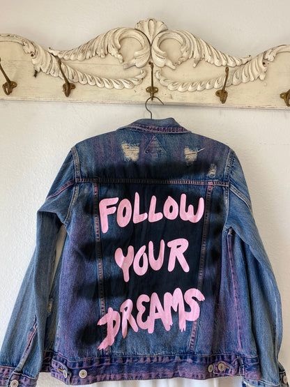 Trestles Clothing Company distressed denim jacket with hand-painted pink Follow Your Dreams text and spray paint