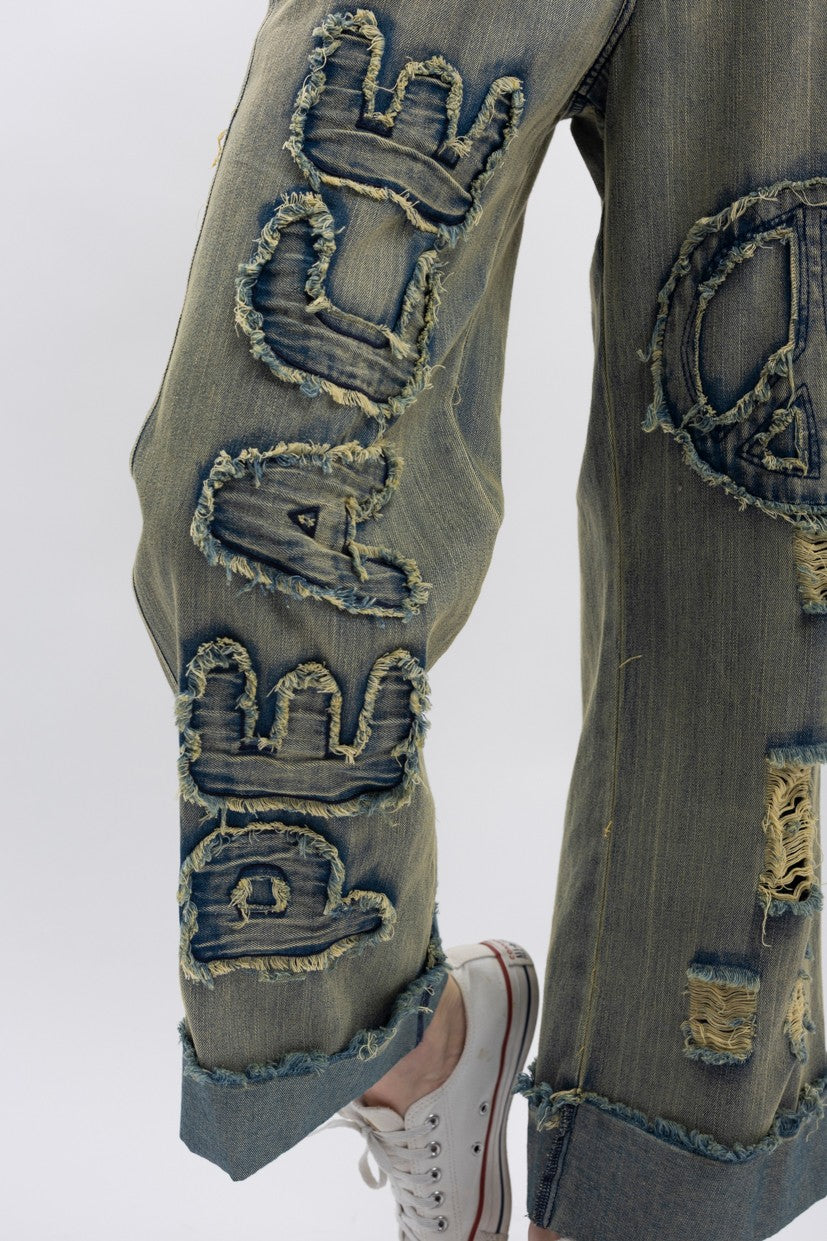 Trestles Clothing Company distressed wide-leg denim jeans with peace sign applique and frayed vintage wash finish