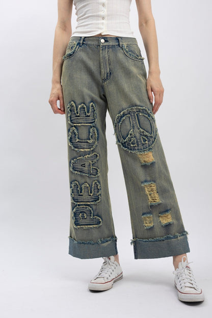 Trestles Clothing Company wide-leg distressed denim jeans with Peace applique and emblem patch in vintage wash
