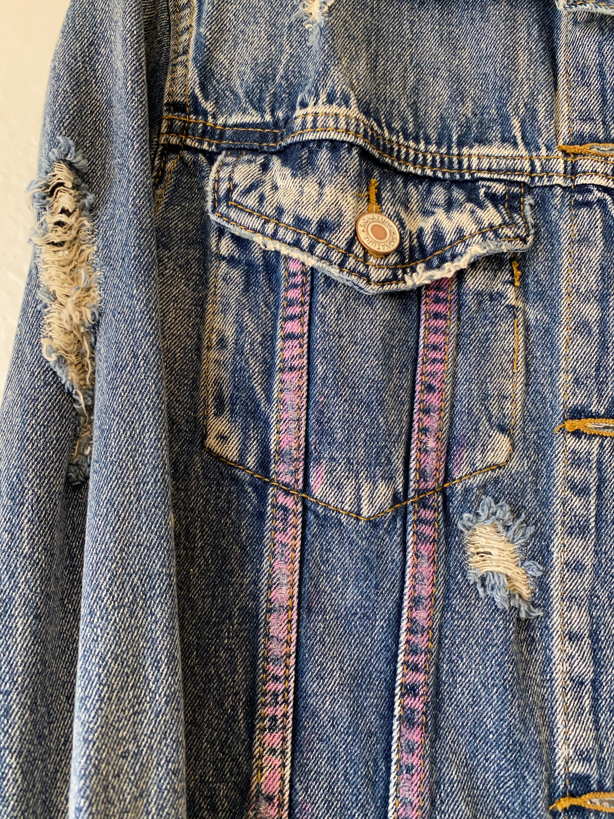 Trestles Clothing Company distressed blue denim jacket with hand-painted pink spray paint accents on the pocket.