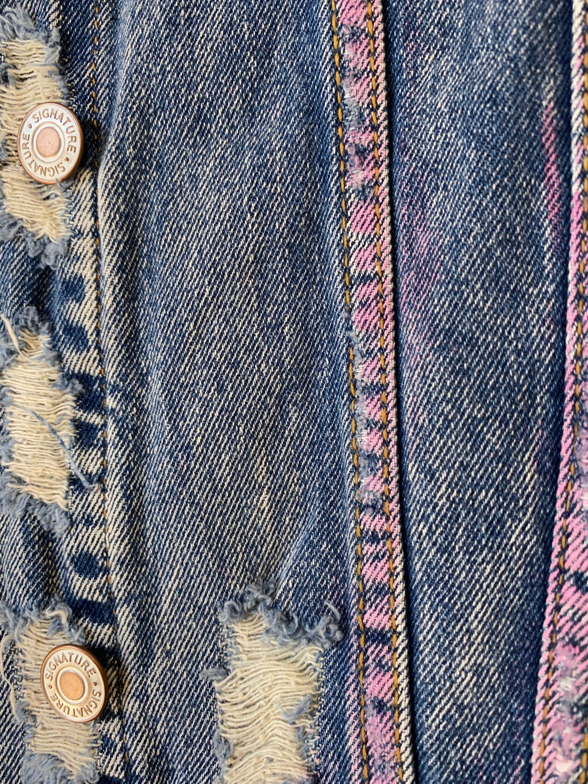 Trestles Clothing Company distressed blue denim jacket with hand-painted pink spray paint details and metal buttons.