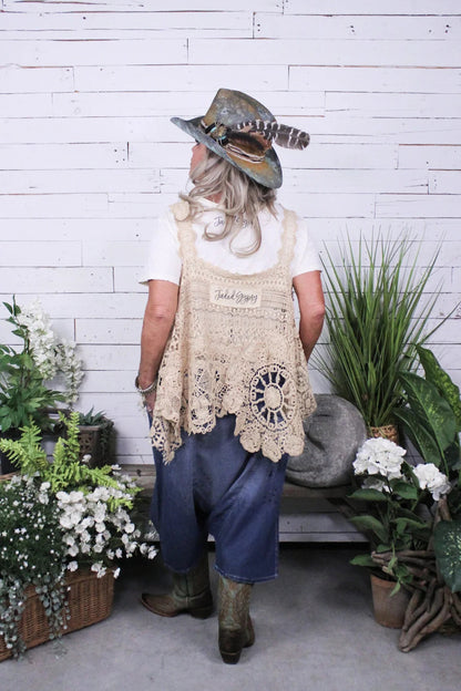 Trestles Clothing Company Earthsong harem pants in dark denim paired with a beige crochet vest and feathered hat
