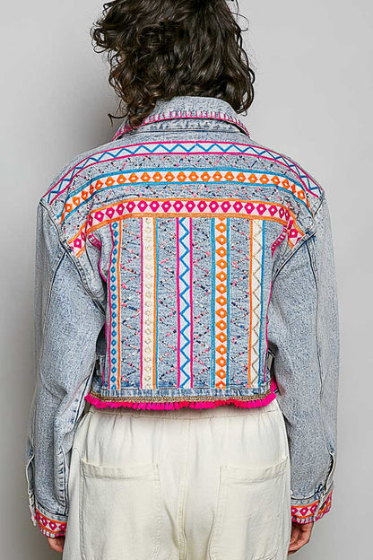 Trestles Clothing Company cropped denim jacket with vibrant hand-embroidered Aztec motifs and pink tassel hem detail