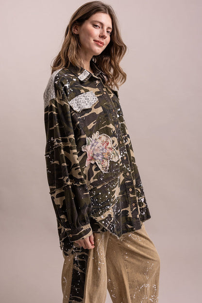 Trestles Clothing Company camo shacket with floral patches, paint splatters, and lace details on a female model.