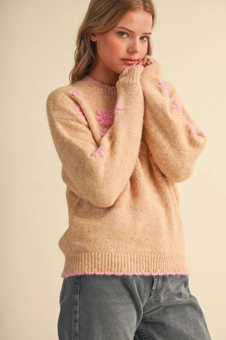 Trestles Clothing Company beige knit sweater with pink floral embroidery and scalloped trim worn by a blonde model