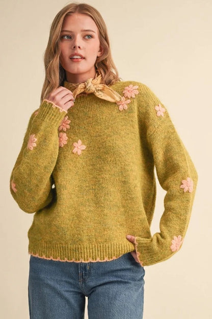 Trestles Clothing Company olive green knit sweater with pink floral embroidery, scalloped edges, and drop shoulders.