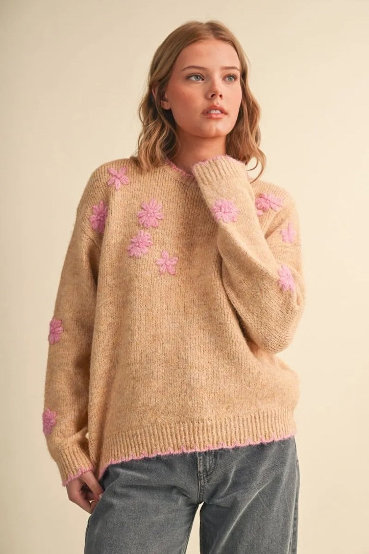 Trestles Clothing Company beige knit sweater with pink floral embroidery, scalloped edges, and a relaxed fit.