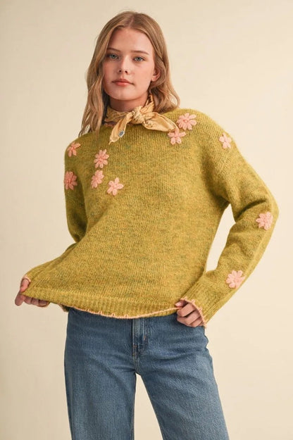 Trestles Clothing Company olive green knit sweater with pink floral embroidery, scalloped edges, and drop shoulders.