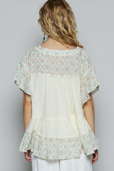 Back view of Trestles Clothing Company ruffle sleeve top in cream double gauze with floral print trim and tiered hem.