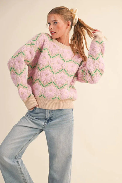 Trestles Clothing Company fuzzy floral knit sweater with pink flowers, green stems, and beige ribbed trim on a model