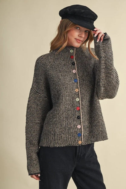 Trestles Clothing Company cozy knit sweater with mismatched colorful buttons worn by a woman in a black cap
