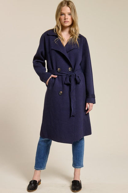 Model wearing a navy blue Trestles Clothing Company Beckham midi sweater coat with a tie belt over jeans